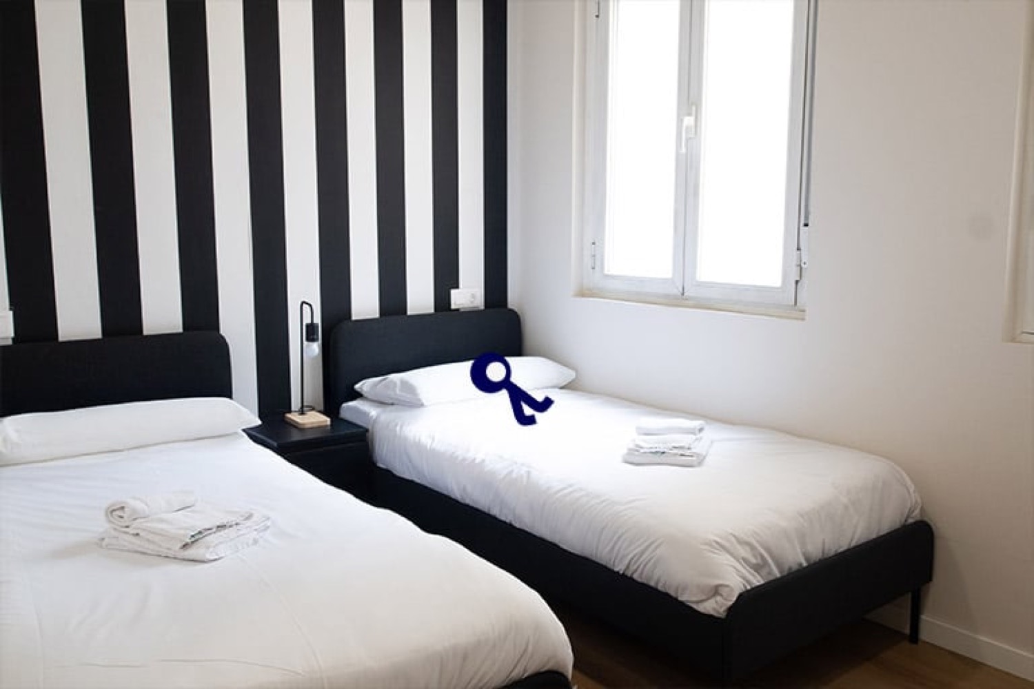 Habitación doble privada con dos camas individuales y pared de rayas